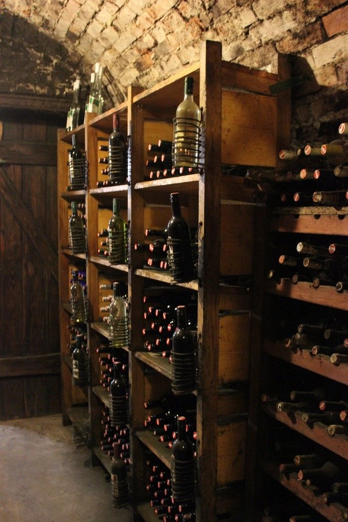 Botellas de vino en las estanterías de una bodega abovedada