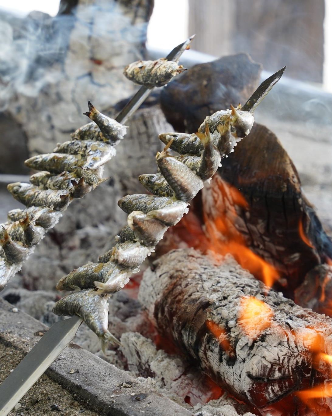 Espetos de sardinas asándose junto a las brasas