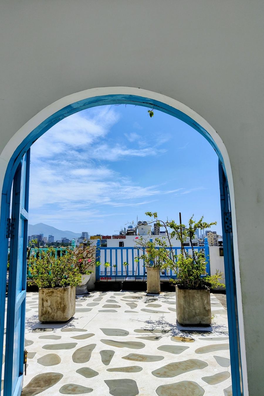 Puerta en arco que se abre a una terraza encalada